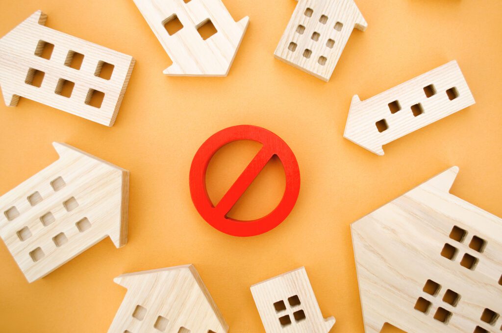 Wooden houses and red prohibition symbol.